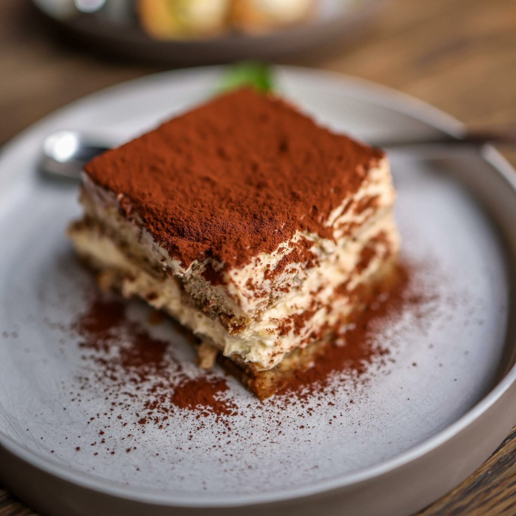 Close-up of a delectable tiramisu slice on a rustic table, perfect for dessert lovers.